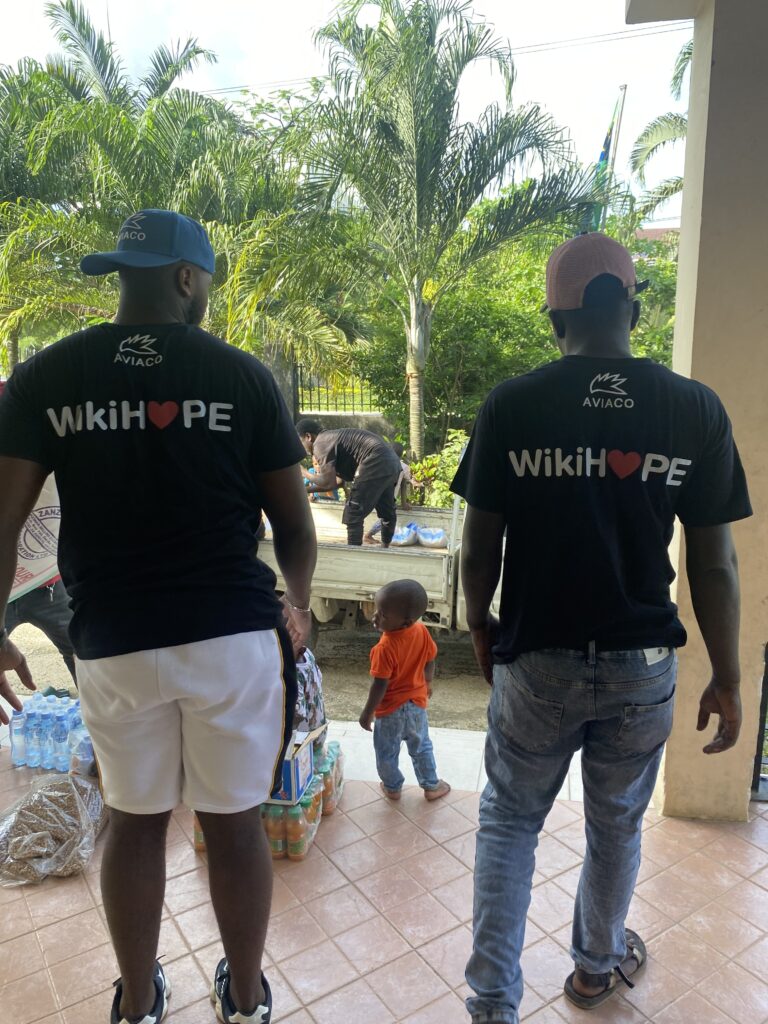 adults wearing Wikihope tee shirt and helping the charity to distribute the donations to the children of an orphanage to help Social inclusion